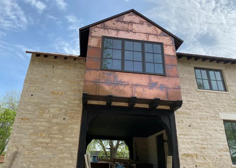 Copper metal panel facade on a stone building for Roof Repair in Morrilton